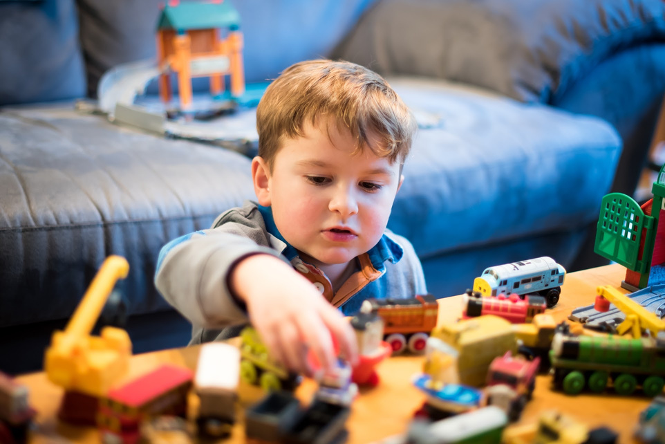 Kid Playing with Train Toys